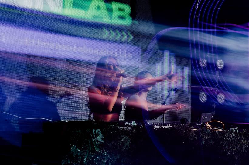 DJ on the mic in front of the Spin Lab wall